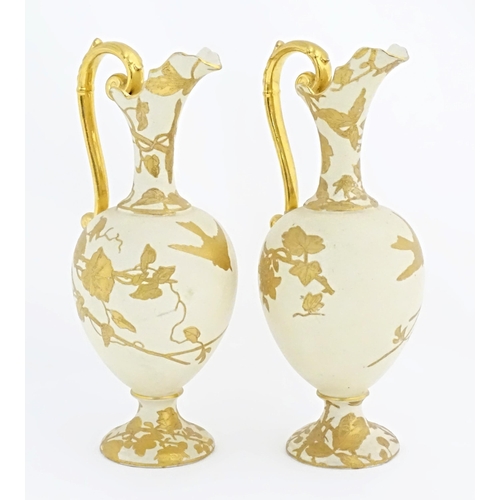 65 - Two Continental ewers with loop handles with gilt decoration depicting birds, flowers and foliage. A... 