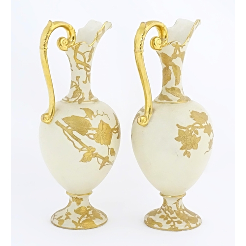 65 - Two Continental ewers with loop handles with gilt decoration depicting birds, flowers and foliage. A... 