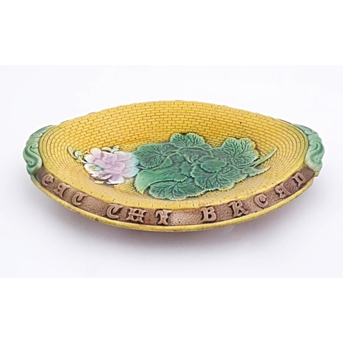 77 - A Victorian majolica bread plate with flowers and foliage to centre, the rim with motto Eat the Brea... 