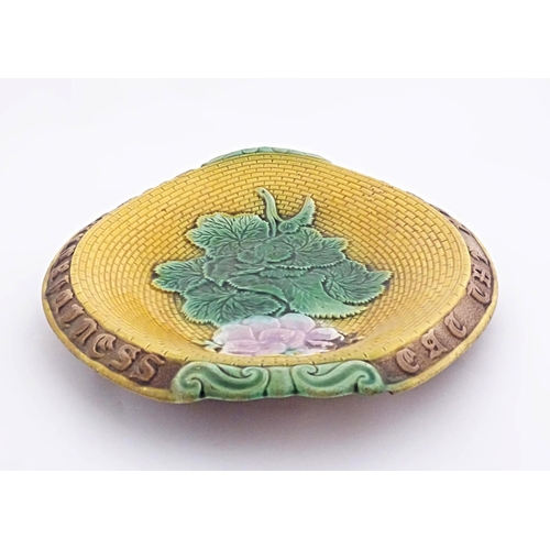 77 - A Victorian majolica bread plate with flowers and foliage to centre, the rim with motto Eat the Brea... 