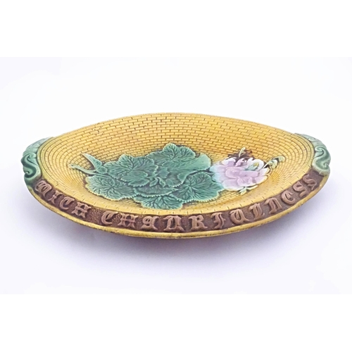 77 - A Victorian majolica bread plate with flowers and foliage to centre, the rim with motto Eat the Brea... 