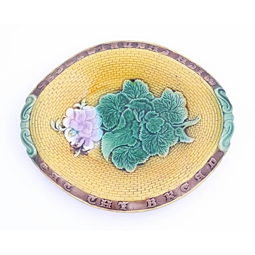 77 - A Victorian majolica bread plate with flowers and foliage to centre, the rim with motto Eat the Brea... 