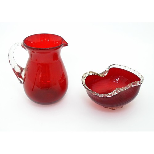 178 - Two items of glassware comprising a red glass water jug with clear glass handle, and a red glass bow... 