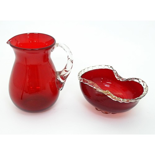 178 - Two items of glassware comprising a red glass water jug with clear glass handle, and a red glass bow... 