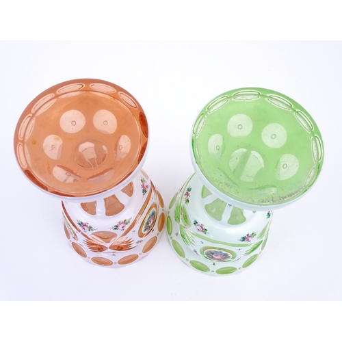 182 - Two Bohemian glass pedestal vases in peach and pale green with white overlay and floral decoration. ... 