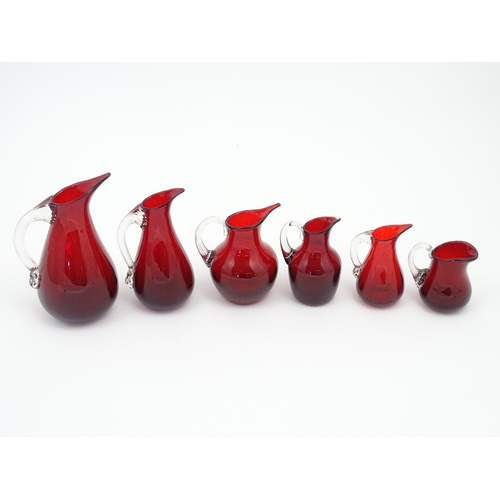 197 - Assorted red glass jugs with clear class handles. To include some Whitefriars examples. The tallest ... 