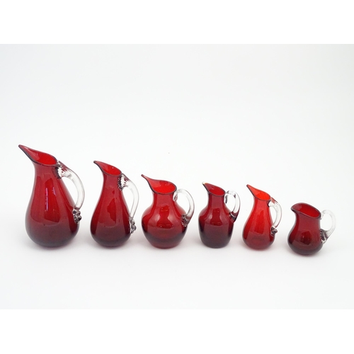 197 - Assorted red glass jugs with clear class handles. To include some Whitefriars examples. The tallest ... 