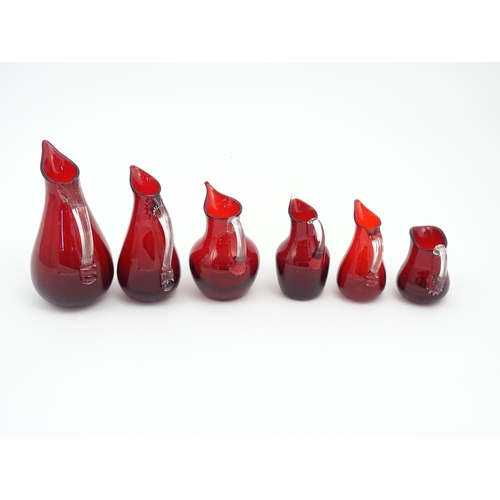 197 - Assorted red glass jugs with clear class handles. To include some Whitefriars examples. The tallest ... 