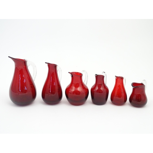 197 - Assorted red glass jugs with clear class handles. To include some Whitefriars examples. The tallest ... 