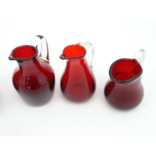 197 - Assorted red glass jugs with clear class handles. To include some Whitefriars examples. The tallest ... 