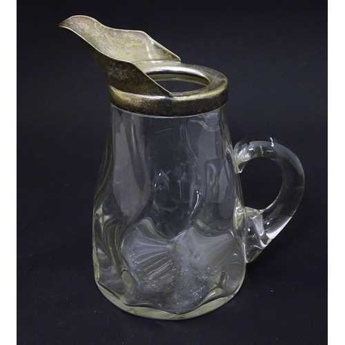 201 - A glass jug with loop handle and silver plate mounts. Approx 7 1/2