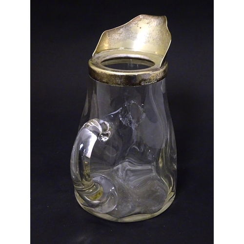 201 - A glass jug with loop handle and silver plate mounts. Approx 7 1/2