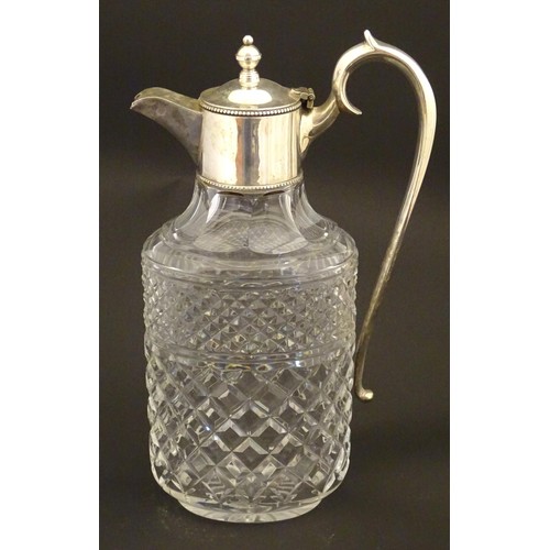 204 - A glass claret jug of ovoid form with silver plate mounts and handle.  Approx. 11 /2