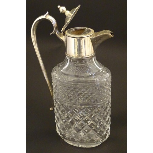 204 - A glass claret jug of ovoid form with silver plate mounts and handle.  Approx. 11 /2