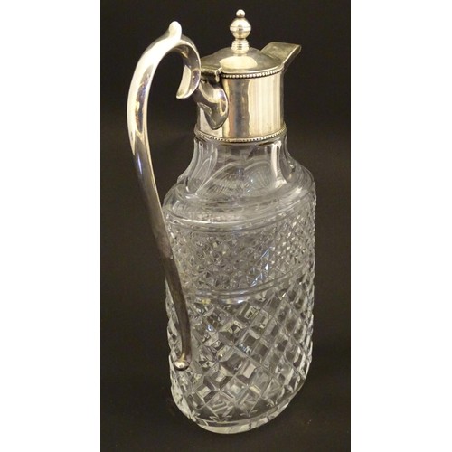 204 - A glass claret jug of ovoid form with silver plate mounts and handle.  Approx. 11 /2