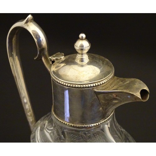 204 - A glass claret jug of ovoid form with silver plate mounts and handle.  Approx. 11 /2