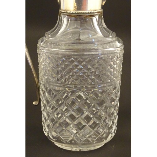 204 - A glass claret jug of ovoid form with silver plate mounts and handle.  Approx. 11 /2