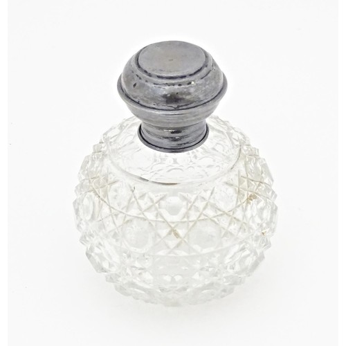 216 - A cut glass scent / perfume bottle with silver top, hallmarked Birmingham 1919. Approx. 3 1/2