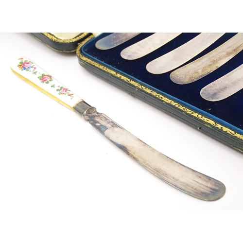 518 - A set of six tea knives with silver collars and gilt and floral decorated ceramic handles, the colla... 