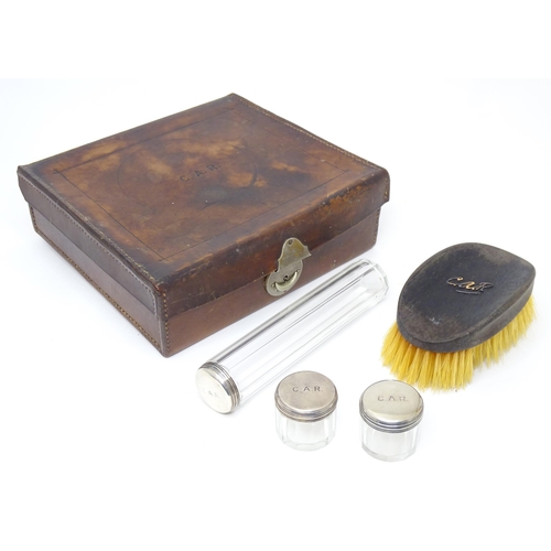 522 - A leather vanity / travelling case  with fitted interior and containing 3 glass bottles with silver ... 