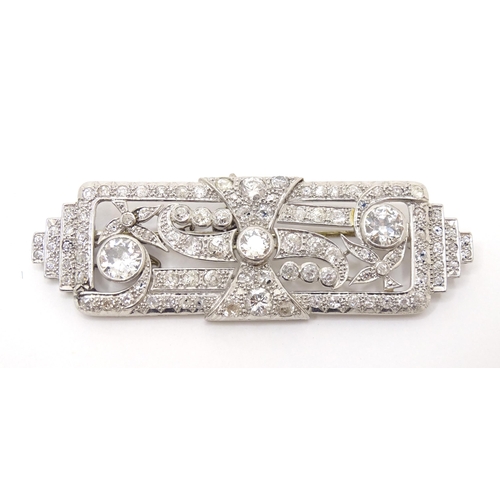 661 - An impressive Art Deco white metal brooch set with a profusion of diamonds. The two largest diamonds... 