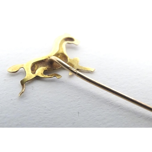 670 - A gold and yellow metal stick pin surmounted by a horse. Marked 10k. Approx 2 3/4