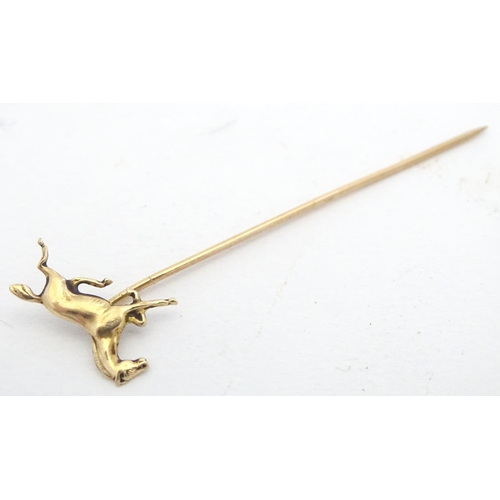 670 - A gold and yellow metal stick pin surmounted by a horse. Marked 10k. Approx 2 3/4