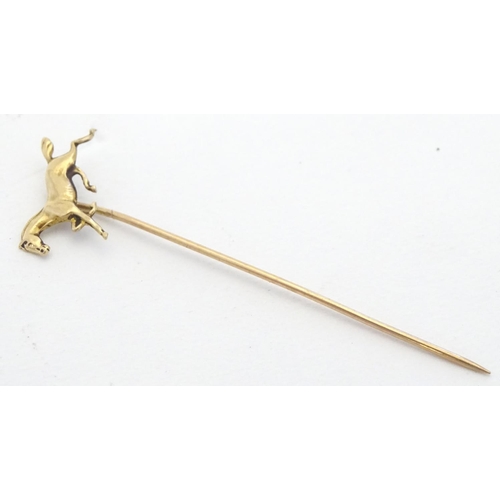 670 - A gold and yellow metal stick pin surmounted by a horse. Marked 10k. Approx 2 3/4