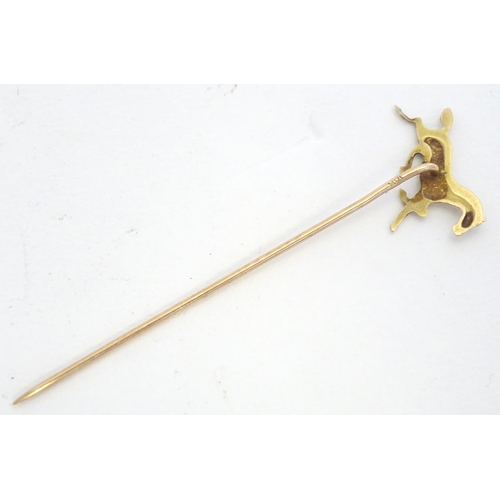 670 - A gold and yellow metal stick pin surmounted by a horse. Marked 10k. Approx 2 3/4