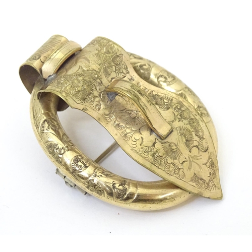 752 - A Victorian gilt metal brooch of buckle form with engraved floral detail. Approx. 2