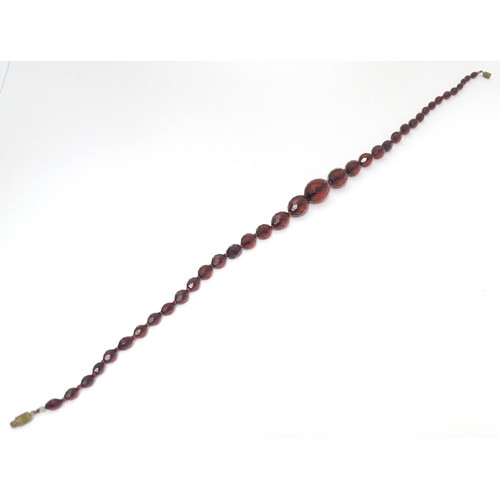 758 - A necklace of facet cut graduated cherry amber coloured bead. Approx 20