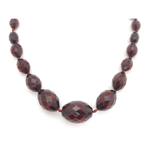 758 - A necklace of facet cut graduated cherry amber coloured bead. Approx 20