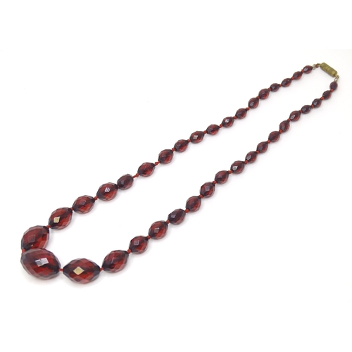 758 - A necklace of facet cut graduated cherry amber coloured bead. Approx 20