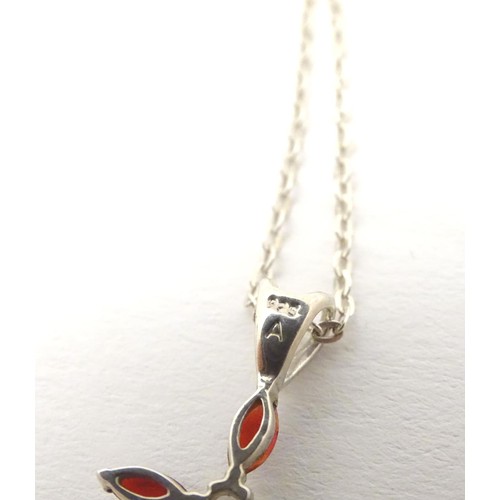 759 - A silver pendant of cross form set with red and white stones approx 1