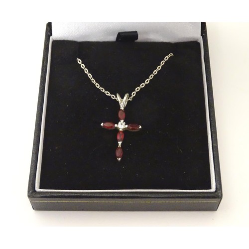 759 - A silver pendant of cross form set with red and white stones approx 1