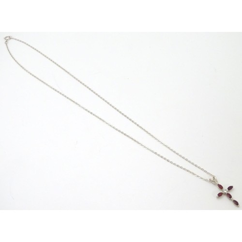 759 - A silver pendant of cross form set with red and white stones approx 1