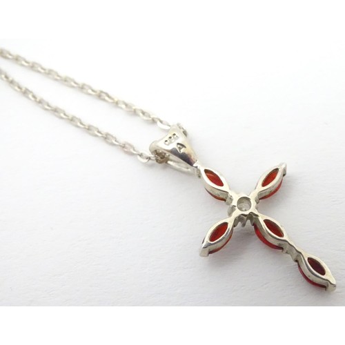 759 - A silver pendant of cross form set with red and white stones approx 1