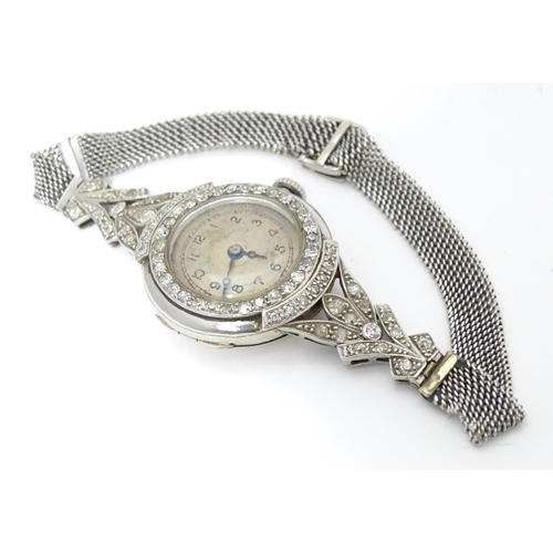 780 - A platinum and white metal ladies wrist watch set with a profusion of diamonds. The case approx. 3/4... 