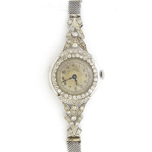 780 - A platinum and white metal ladies wrist watch set with a profusion of diamonds. The case approx. 3/4... 