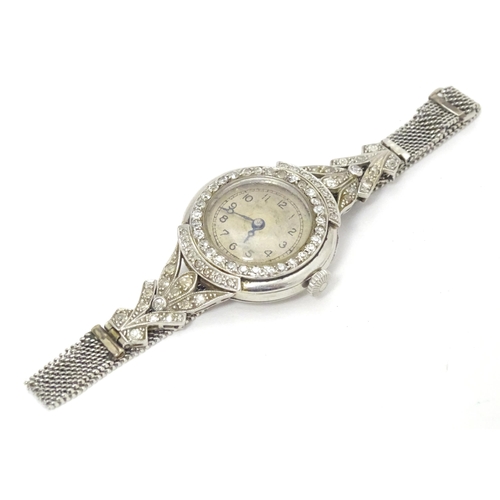 780 - A platinum and white metal ladies wrist watch set with a profusion of diamonds. The case approx. 3/4... 