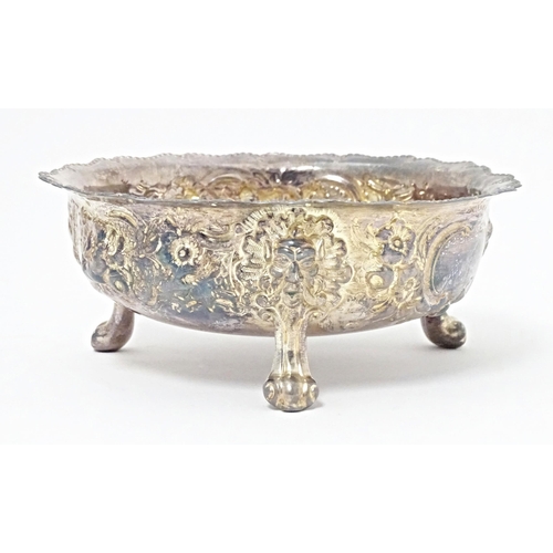 243 - A Victorian silver bowl with embossed decoration standing on three feet, hallmarked London 1878, mak... 