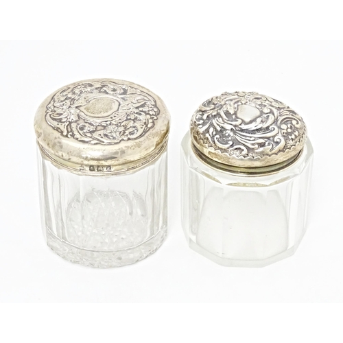 263 - Two glass dressing table / toilet jars with silver tops, one hallmarked Birmingham 1906, the other B... 