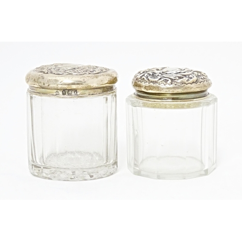 263 - Two glass dressing table / toilet jars with silver tops, one hallmarked Birmingham 1906, the other B... 