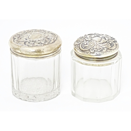 263 - Two glass dressing table / toilet jars with silver tops, one hallmarked Birmingham 1906, the other B... 