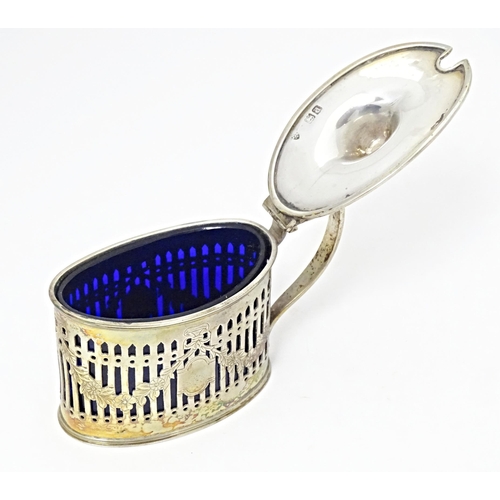 285 - A silver mustard pot with hinged lid, pierced detail and blue glass liner, hallmarked London1899, ma... 