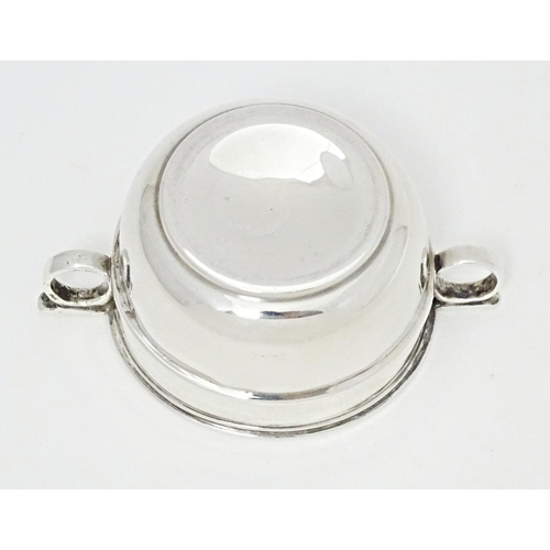 294 - A silver salt formed as a miniature porringer with twin loop handles, hallmarked London 1914, maker ... 