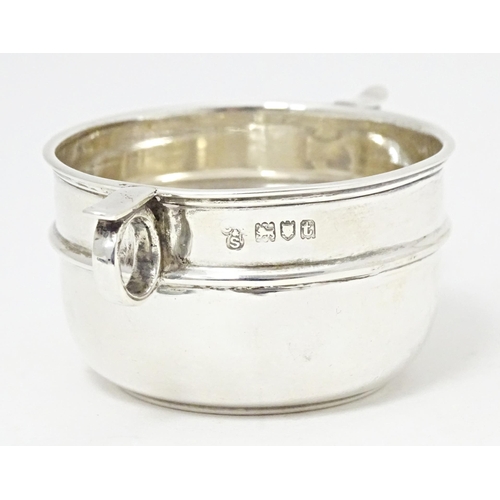 294 - A silver salt formed as a miniature porringer with twin loop handles, hallmarked London 1914, maker ... 