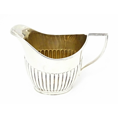 303 - A Victorian silver cream jug with fluted detail, hallmarked Sheffield 1894, maker John Round & Son L... 