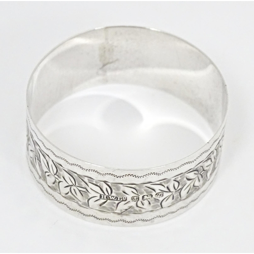 304 - A silver napkin ring with engraved foliate detail, hallmarked Birmingham 1924, maker Henry Williamso... 