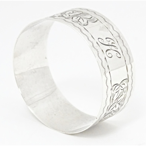 304 - A silver napkin ring with engraved foliate detail, hallmarked Birmingham 1924, maker Henry Williamso... 